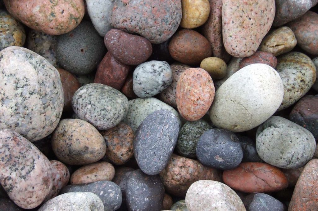 An overhead photo of smooth stones in various colors, like those you'd find along a riverbed.